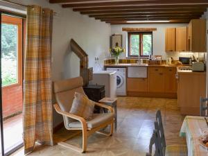 a kitchen with a chair and a stove at Eden Cottage in Little Hautbois