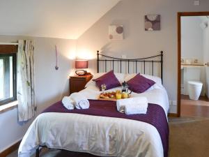 a bed with towels and a tray of food on it at Eden Cottage in Little Hautbois
