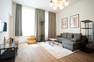 salon z kanapą i stołem w obiekcie Spacious apartment with huge shared terrace and grill located between city centre and Donau river w Wiedniu