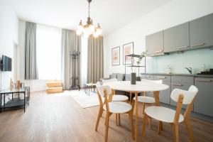 kuchnia i jadalnia ze stołem i krzesłami w obiekcie Spacious apartment with huge shared terrace and grill located between city centre and Donau river w Wiedniu