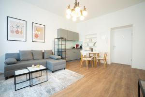 salon z kanapą i stołem w obiekcie Spacious apartment with huge shared terrace and grill located between city centre and Donau river w Wiedniu