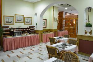 a restaurant with two tables and chairs and a counter at Hotel Regio 2 in Cádiz