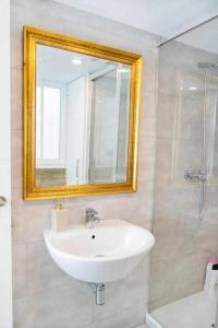 y baño con lavabo blanco y espejo. en Lovely Duplex, en Sevilla