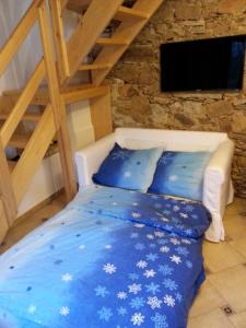ein Bett mit einer blauen Decke und einer Holzleiter in der Unterkunft Apartmán Krátká in Krátká