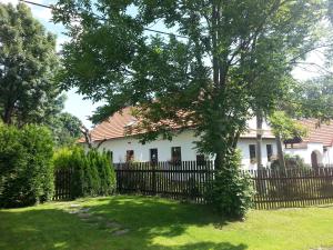 ein weißes Haus mit einem Zaun und einem Baum in der Unterkunft Apartmán Krátká in Krátká