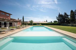 duży basen na dziedzińcu z krzesłami w obiekcie Guadalupe Tuscany Resort w mieście Braccagni