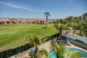 eine Aussicht über einen Golfplatz mit Palmen in der Unterkunft 3h La Quinta - Wonderful 4 Bed Villa Wth Pool in San Miguel de Abona