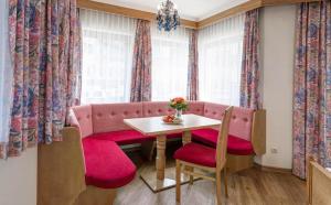 a dining room with a pink couch and a table at Heart Hotel Nordstern in Mayrhofen