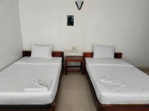 duas camas sentadas uma ao lado da outra num quarto em city inn hotel em Siem Reap