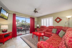 uma sala de estar com um sofá vermelho e uma televisão em Ocean Village Club K12, 2 Bedrooms, Sleeps 4, Heated Pool, WiFi em Saint Augustine