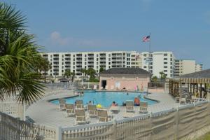 a swimming pool with chairs and a hotel in the background at Jetty East A516 in Destin