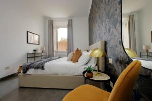 1 dormitorio con cama extragrande y silla amarilla en Tiberina, en Roma