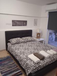 1 cama blanca y negra con 2 almohadas en Nicosia rest and relax 1 bedroom apartment, en Nicosia