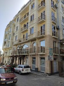 a large building with cars parked in front of it at Pushkin street Pearl in Kutaisi