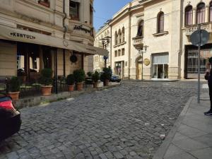a cobblestone street in a city with buildings at Pushkin street Pearl in Kutaisi
