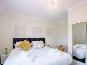 a white bedroom with a large bed with towels on it at Eves Retreat in Wragby