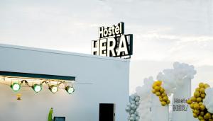 a sign on the side of a building with balloons at HERA HOSTEL in Chau Doc