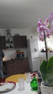 une cuisine avec une table et un vase de fleurs violettes dans l'établissement Casa Rodica, à Vatra Dornei