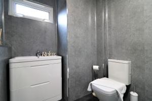 a bathroom with a toilet and a sink and a window at Signature - Carnoustie House in East Kilbride +24 photos