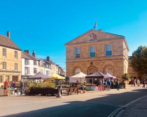 a group of people walking around a market in front of a building at Detached annex in centre of Woodstock, Cotswolds in Woodstock