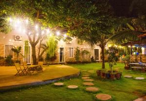 Hồ Cốc Homestay في هو كوك: منزل مع حديقة في الليل مع أضواء
