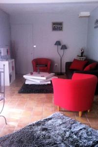 - un salon avec des chaises rouges et un canapé dans l'établissement Suite de l'olivier au Mas au Coeur de la Provence &SPA, à Saint-Cannat