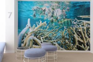 a room with three stools in front of an underwater mural at Iberostar Bahía de Palma - Adults Only in Playa de Palma