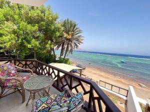 a balcony with chairs and a table and the beach at Moonlight in Dahab