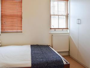 a bedroom with a bed and two windows at The Pad in Lillington