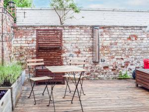 a table and chairs on a patio with a brick wall at The Pad in Lillington