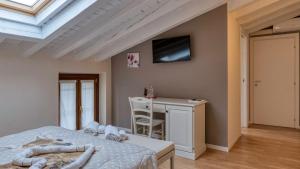 a bedroom with a bed and a desk and a tv at Cascina Volta in Brescia