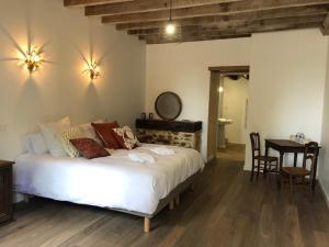 a bedroom with a white bed and a table and chairs at LE DOMAINE DU PETIT TERTRE - SPA EN EXTERIEUR in Saint-Jean-dʼAssé