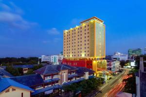 a tall building in the middle of a city at Best Western Plus Makassar Beach in Makassar