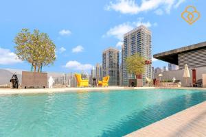 a swimming pool with chairs and buildings in the background at Keysplease 2 BR minutes to Dubai Mall 408, City Walk in Dubai