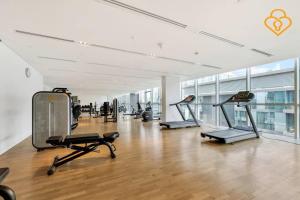 a gym with cardio equipment in a large room with wood floors at Keysplease 2 BR minutes to Dubai Mall 408, City Walk in Dubai