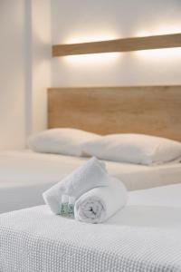zwei Betten mit weißen Handtüchern darauf. in der Unterkunft Calma Beach Hotel in Stavros + 17 Fotos