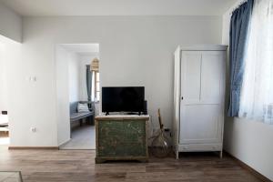 ein Wohnzimmer mit einem TV auf einer Truhe und einer Tür in der Unterkunft Egyszervolt Házikó in Tiszafüred