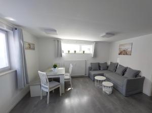ein Wohnzimmer mit Couch und Tisch in der Unterkunft FeWo Friedrichshafen in Friedrichshafen