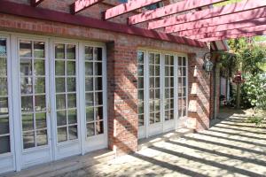 une maison en briques avec des fenêtres blanches et un mur en briques dans l'établissement Les Jardins Carnot, à Compiègne