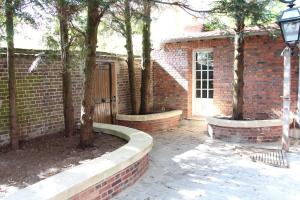 a brick house with a courtyard with trees in front of it at Les Jardins Carnot in Compiègne