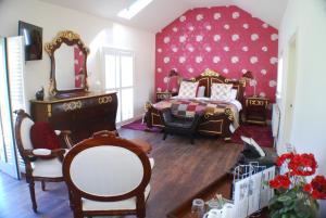a bedroom with a bed and chairs and a mirror at Clonganny House in Ballygarrett