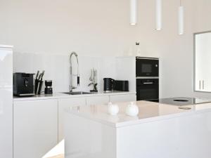 a white kitchen with a black and white appliances at Ferienappartement AM LEUCHTTURM in Mursewiek