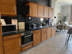 een keuken met houten kasten en een woonkamer bij OrangeHomes Panthera Luxury Apartment in Boedapest