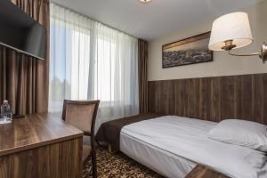 Habitación de hotel con cama y escritorio en Gradiali Wellness and SPA en Palanga