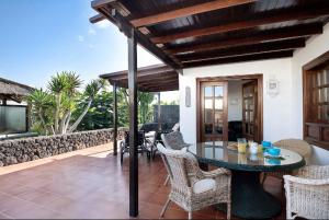 a patio with a table and chairs on a house at Villa Las Palmeras in Playa Blanca