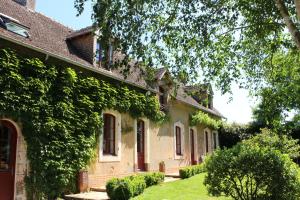 Una casa con l'edera sul lato. di LE DOMAINE DU PETIT TERTRE - SPA EN EXTERIEUR a Saint-Jean-dʼAssé