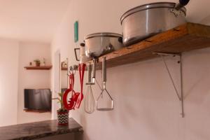 uma cozinha com utensílios pendurados numa parede em Casa do Pepe em Cairu