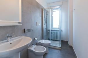 bagno bianco con lavandino e servizi igienici di Top Living Apartments - Carducci a Torino