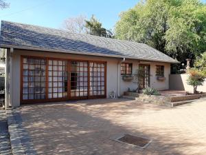 una pequeña casa blanca con un gran garaje en La Casa Guest House, en Bloemfontein