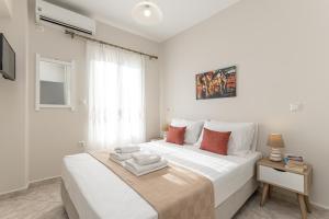 biała sypialnia z dużym białym łóżkiem i oknem w obiekcie Optasia Naxos Center 2 bedroom New Apartment w mieście Naksos